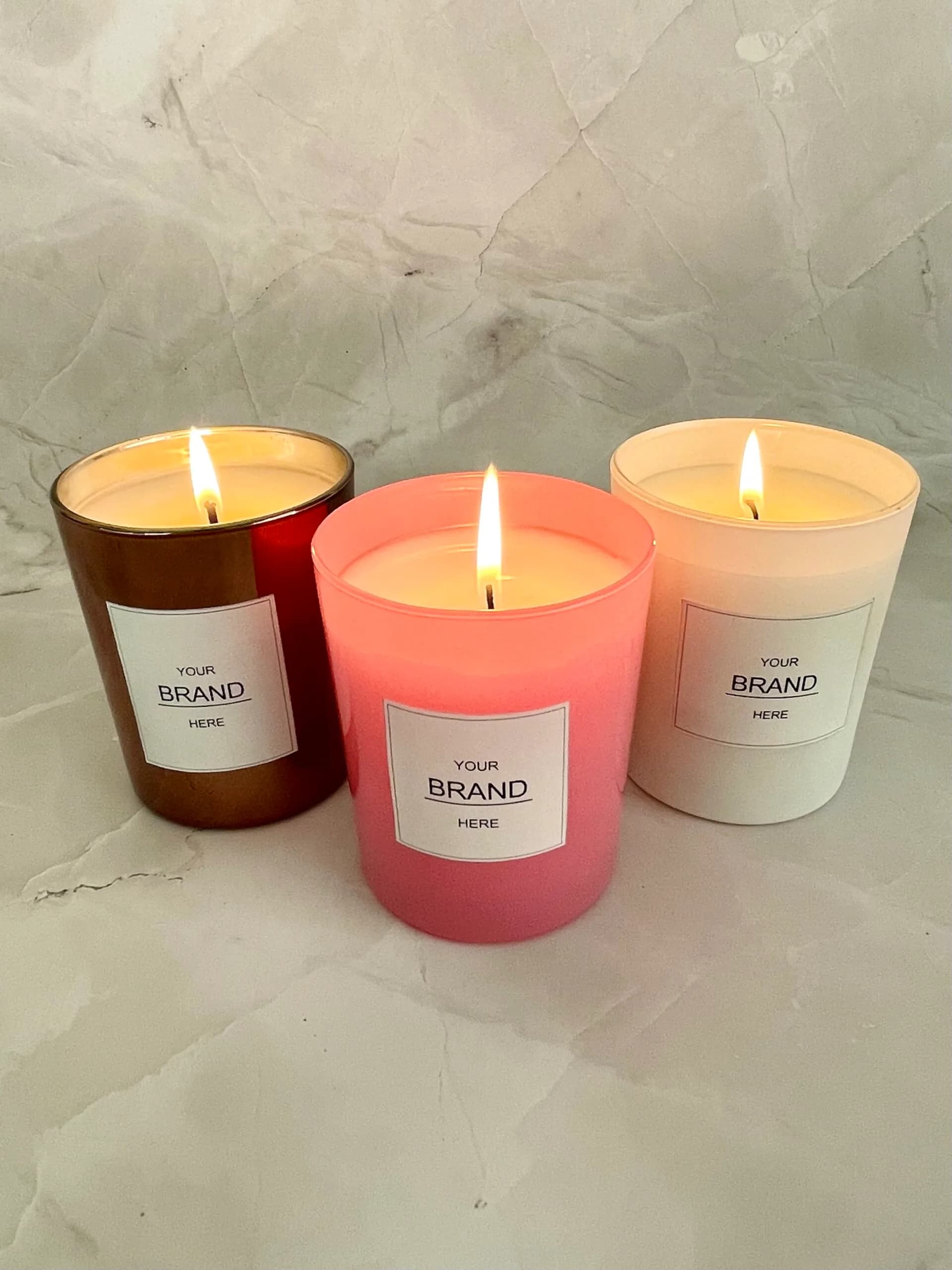 Tre tændte duftlys med etiketten “YOUR BRAND HERE”